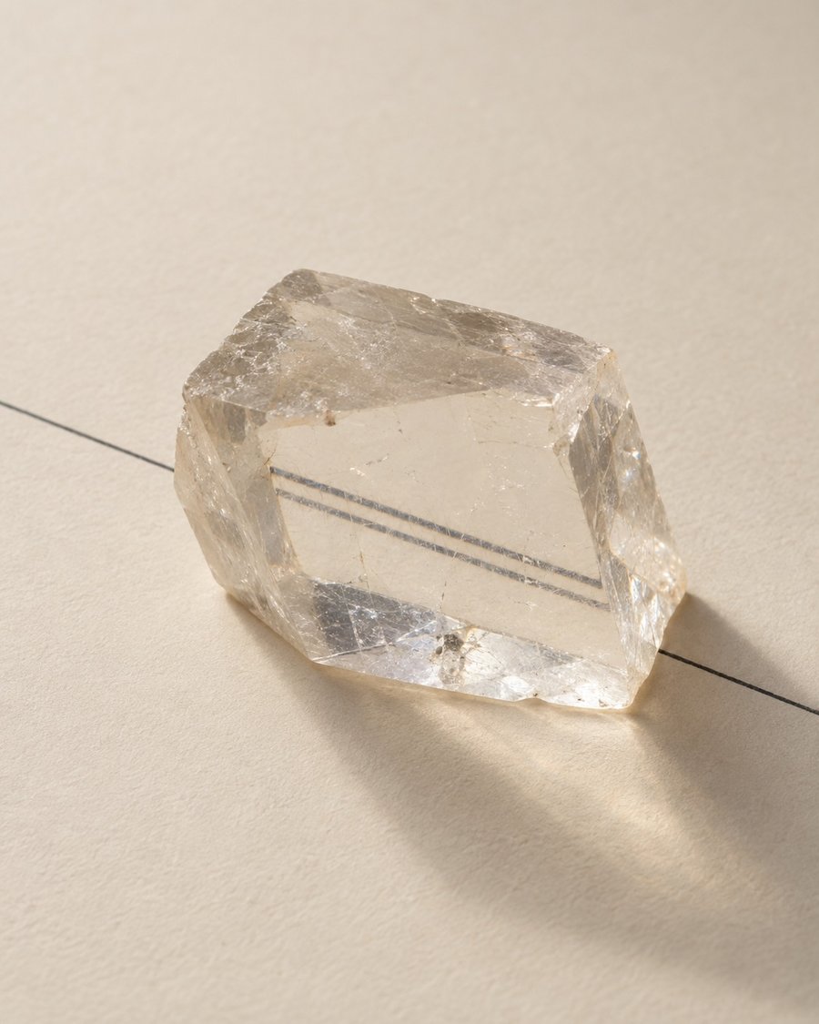 Cristal de espato-da-islândia sobre papel; através dele, uma linha aparece em dobro